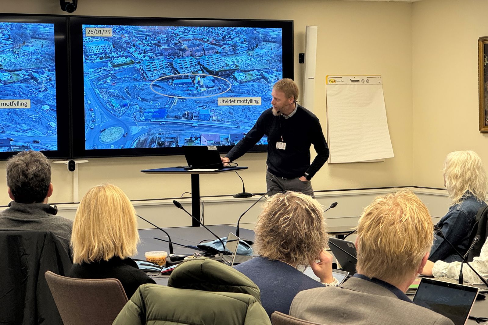 Foto av Bane NORs prosjektsjef som peker på informasjon på en skjerm.