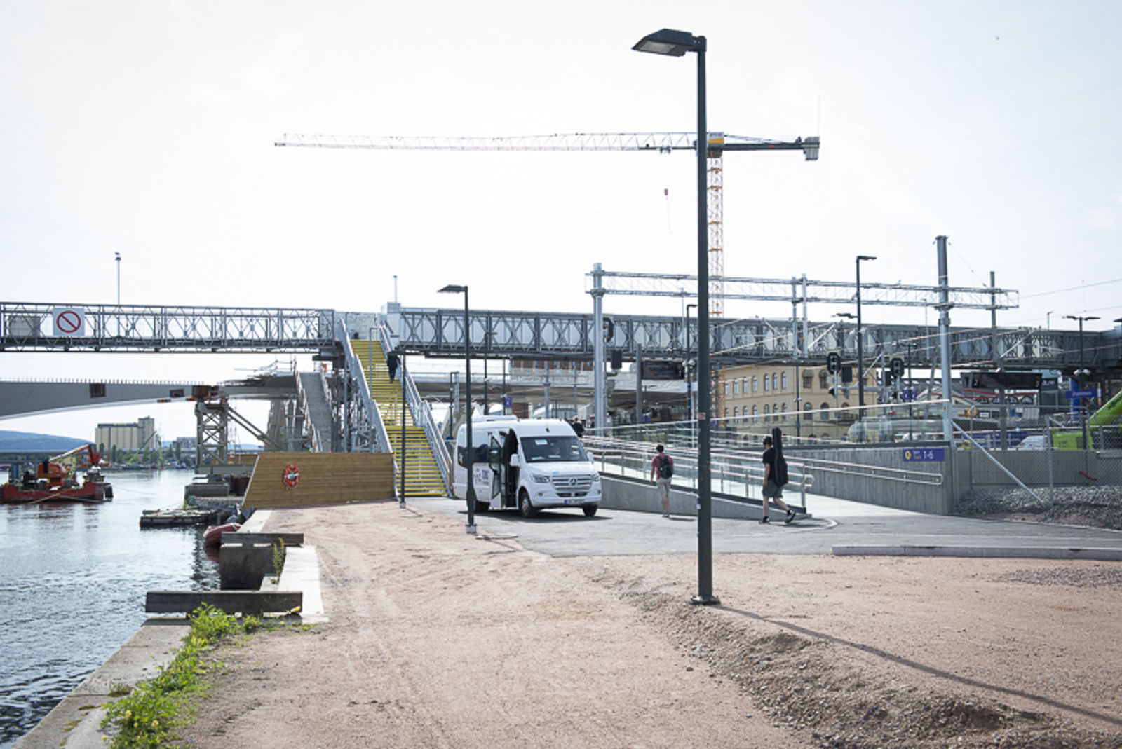 Bilde av gangbrua med taxibuss parkert foran