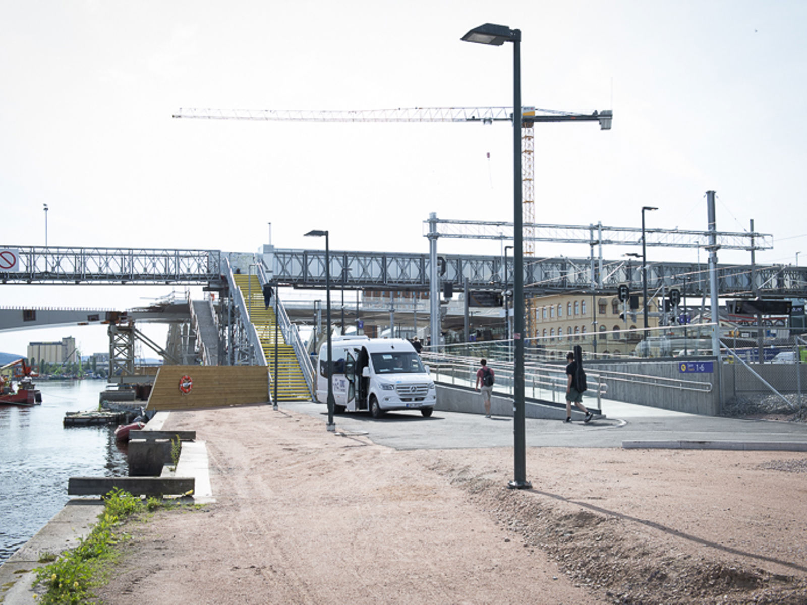 Bilde av gangbrua med taxibuss parkert foran