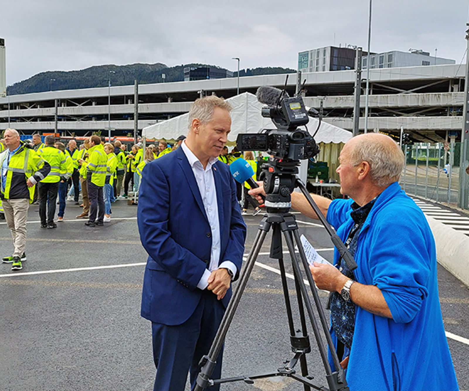 Mann i dress blir intervjuet av mann med TV-kamera.