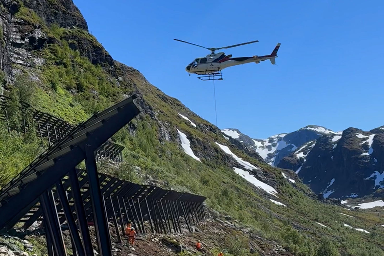 Helikopter som heiser ned materiell i en fjellside