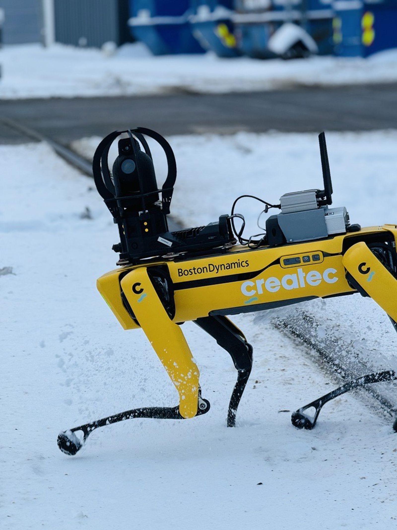 Gul robothund på godsterminal med snø på bakken